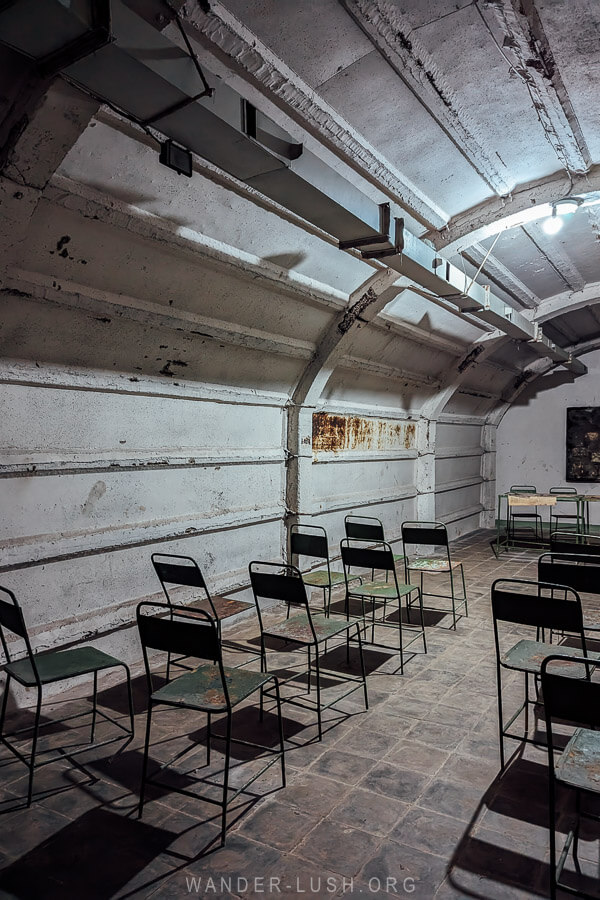 An underground meeting room with folding chairs facing a table inside the Cold War Tunnel in Gjirokaster.