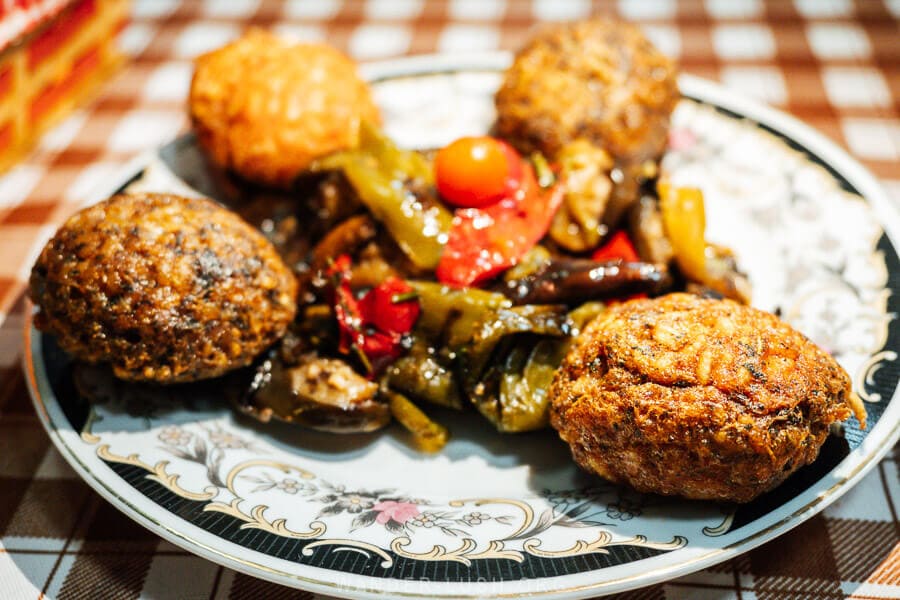 A plate of qifqi rice balls served with grilled vegetables at a local restaurant in Gjirokaster, Albania.