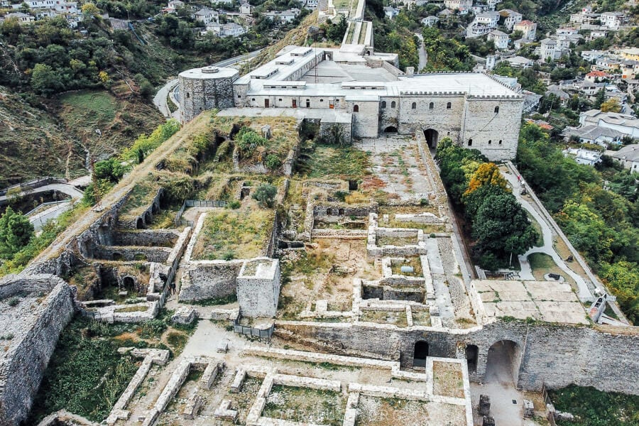 An aerial view of Gjirokaster Castle, with stone walkways and ruins.