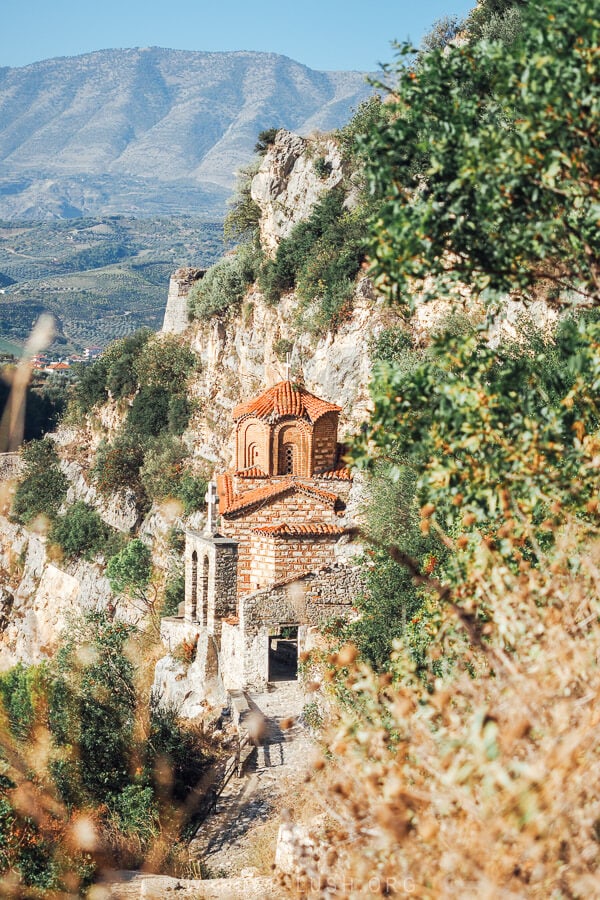 St Michael's Church, a small orange brick church on a cliffside in Berat, Albania.