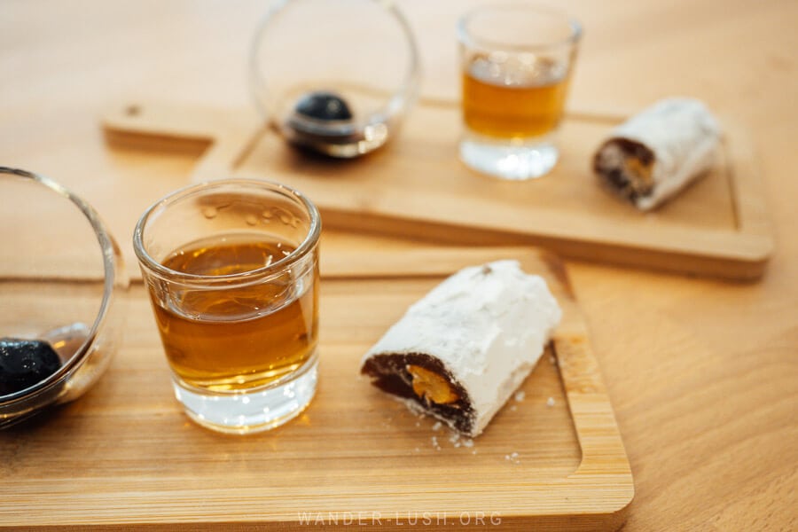 A glass of raki and piece of lokum on a wooden board at a cafe in Berat, Albania.