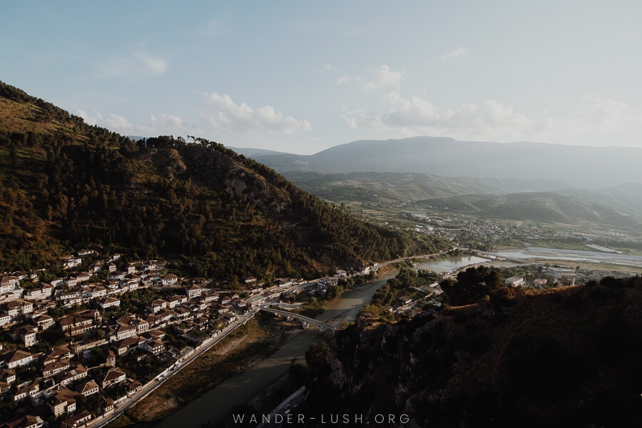 A hazy mountain view with a red-roofed city just visible in the valley below.