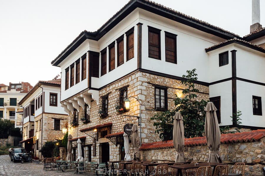 An Ottoman house lit up at night on the edge of historic Ntoltso Square.