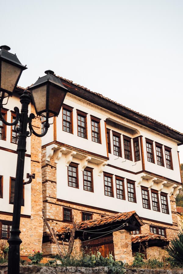 A restored Ottoman mansion in Kastoria framed by a lightpost.