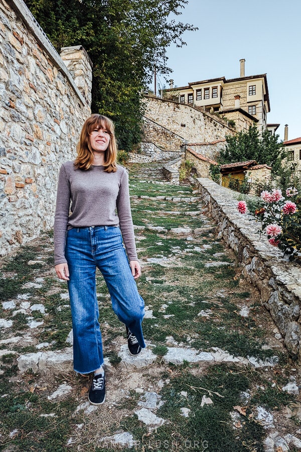 A woman in jeans on a photogenic alleyway in Kastoria, Greece.