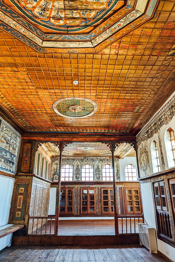 A grand painted room with a decorative wooden ceiling inside Tsiatsiapas Mansion in Kastoria.