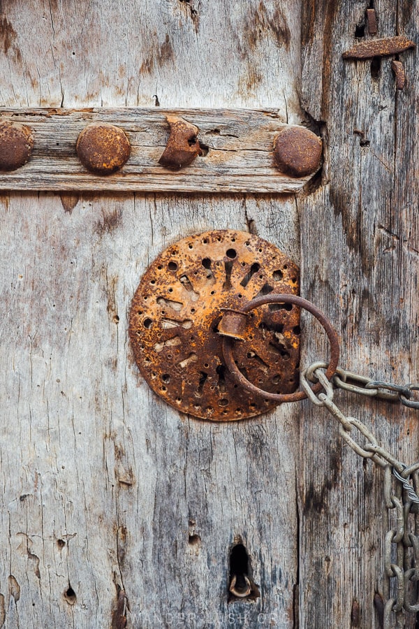 A beautiful old bronze door lock on a wooden church door in Greece.