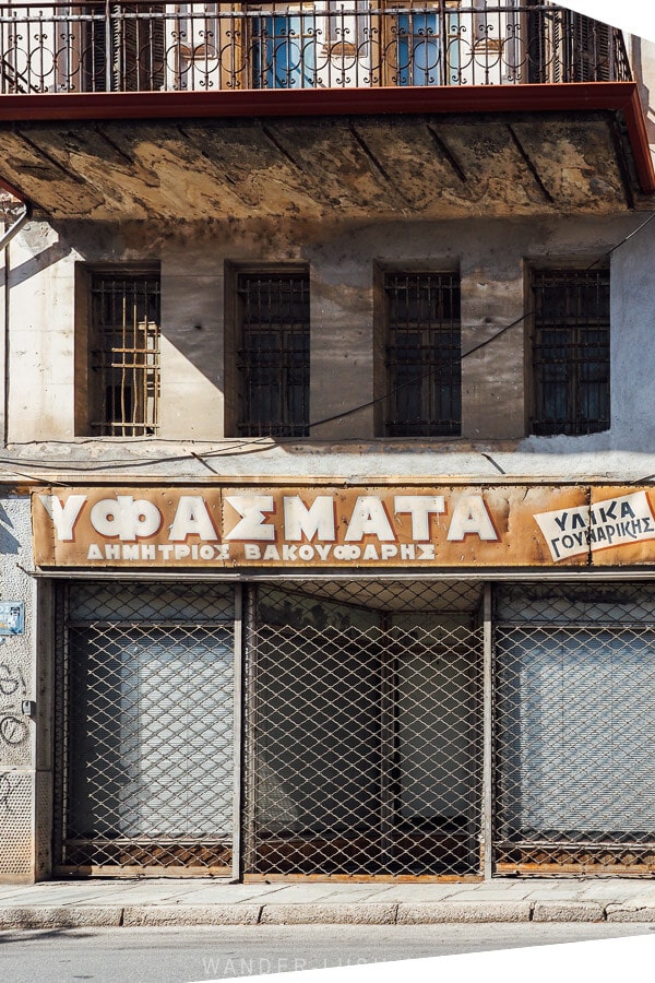 Greek shop sign on an old abandoned building in Kastoria, Greece.