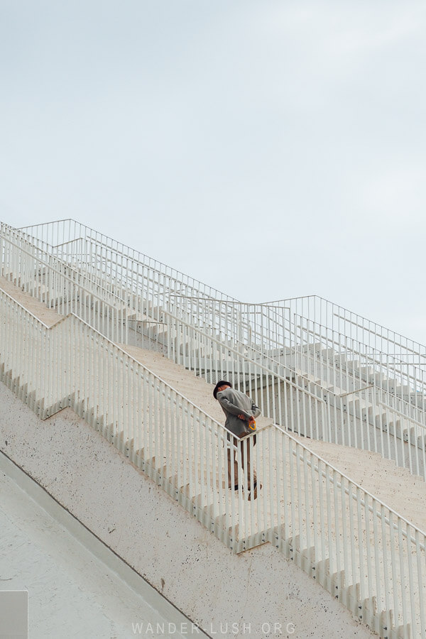 A man dressed in a suit summits the stairs at the newly refurbished Pyramid of Tirana.