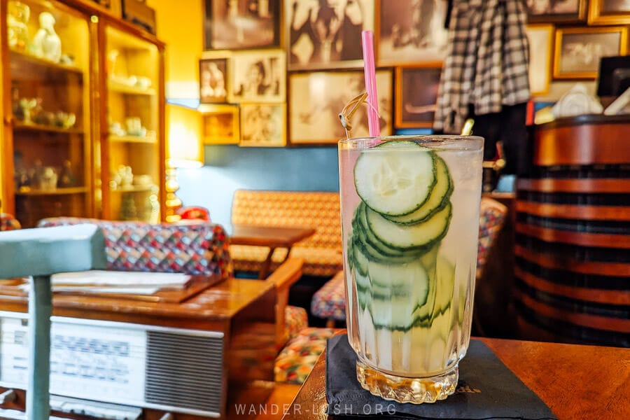 A cocktail with cucumber slices on a table at a cool bar in Tirana.
