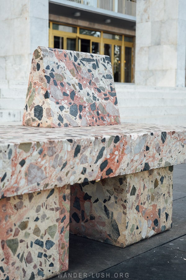 A seat hewn from natural pink stone on the edge of Skanderbeg Square in Tirana.