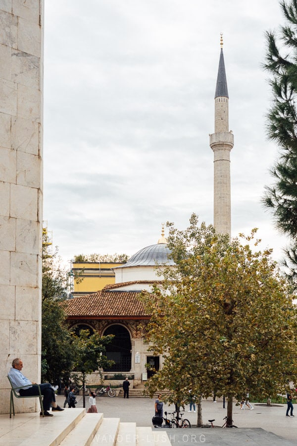 A man sits in front of the old mosque in Tirana.