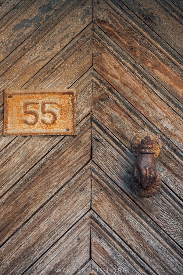 A hand of Fatima door knocker on an old wooden door in Tirana.