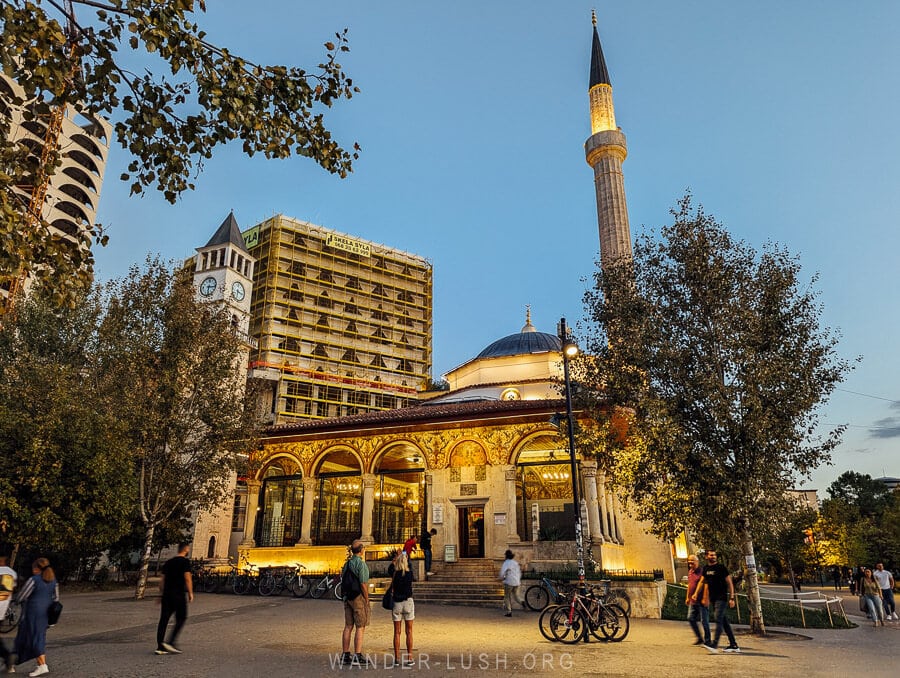 Tourists gather in front of the Etham Bej old mosque in Tirana at night.