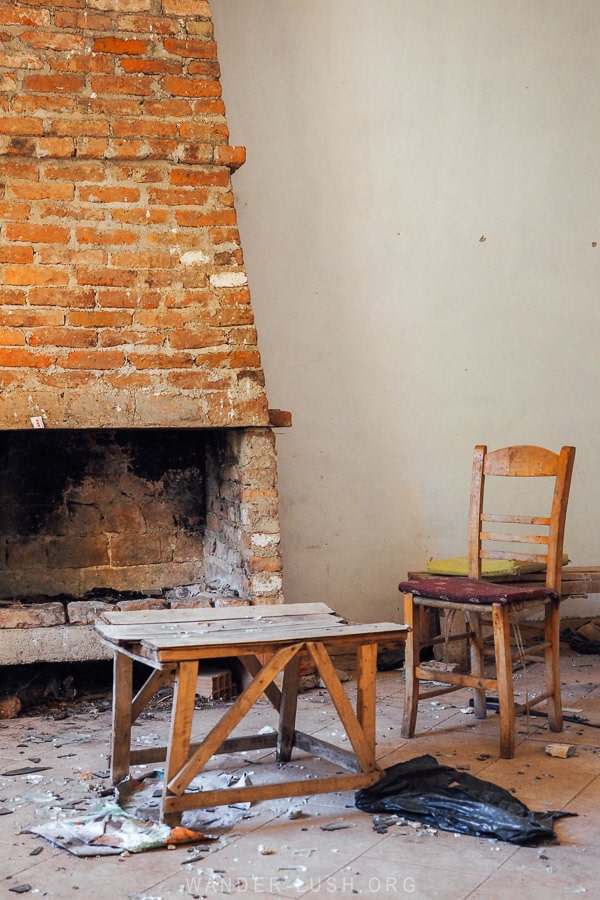 A ramshackle room inside an abandoned hotel in Tirana, with a brick fireplace.