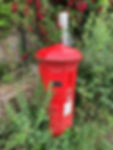 Victorian post box with a wooden post behind it