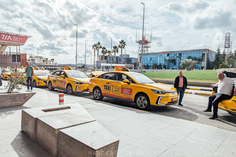 A line of yellow taxis parked at Tirana International Airport.