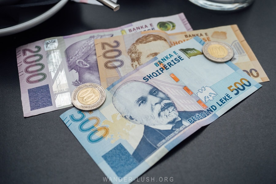 Albanian LEK currency on a black cafe table.