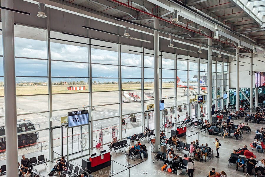 Large glass windows overlooking the runway at Tirana Airport.