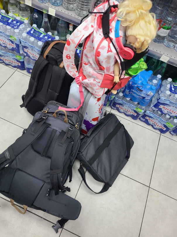 A few carry on bags on the floor of a convenience store. All we have left for travelling.