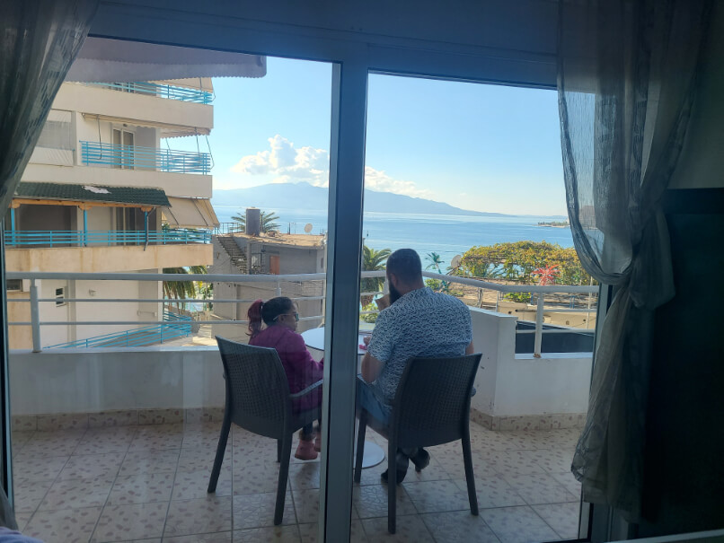 A man and little girl doing schoolwork on their balcony in Saranda Albania during their family gap year