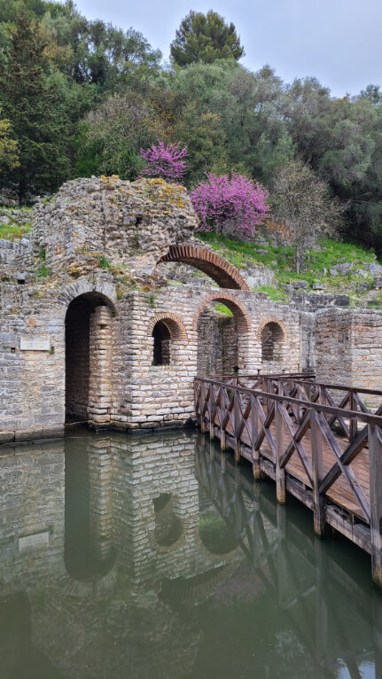 Water around the ancient city at Butrint National park, with a chapel dedicated to the god Asclepius. Purple flowers are in the hills behind the chapel.