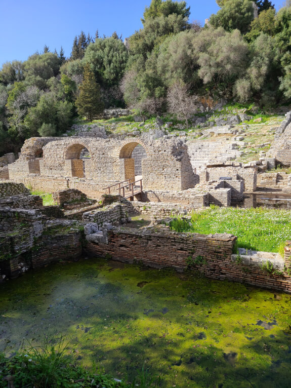 Ancient theatre in the background of the ruined Roman Baths in Butrint National Park