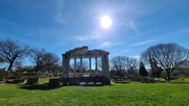 Ruins of the temple at Apollonia with the sun high overhead in a grassy field