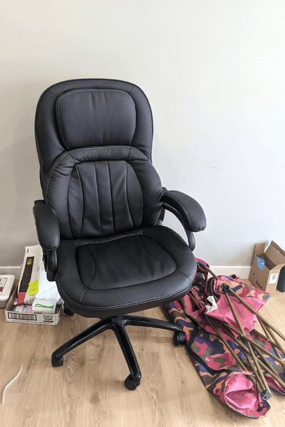 An office chair beside two camping chairs in an otherwise empty living room