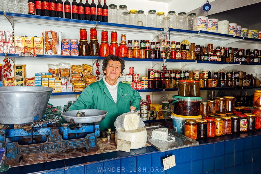 A woman sells wine and local products at a small shop in Leskovik, Albania.