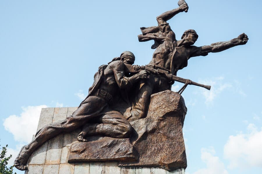 A war memorial in Barmash, Albania depicts two soldiers flying into the air.