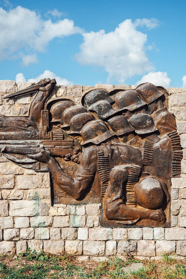 A war memorial in Erseke, Albania depicting a group of soldiers dressed in helmets.