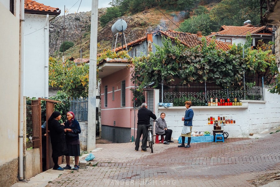 People gathered on the street talking to each other in the small Albanian village of Lin.