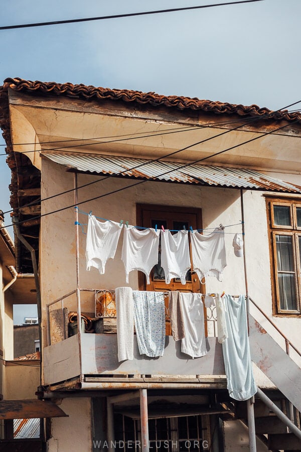 White singles and towels strung from a laundry line on the balcony of a small house in Toplec district, Pogradec.