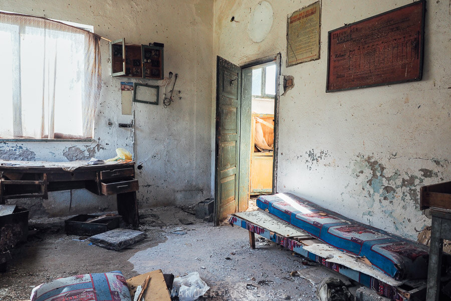 Desks and train timetables inside the office at an abandoned railway station in Xhyre, Albania.