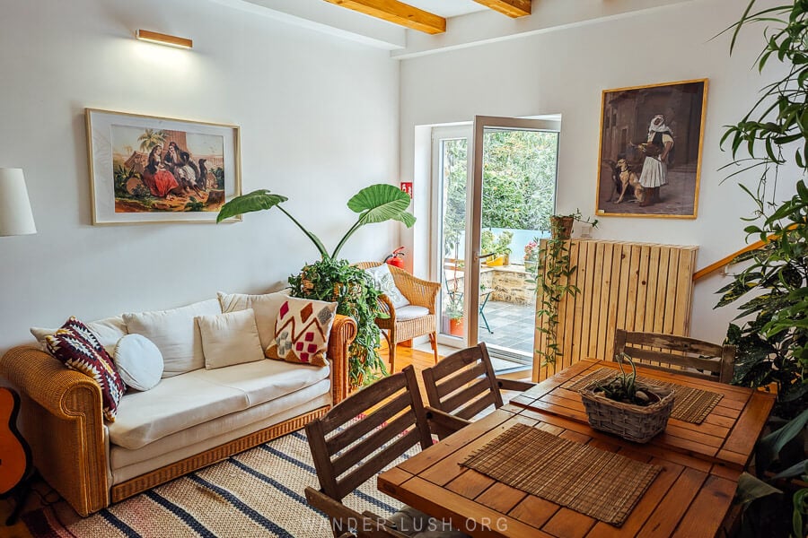 A beautiful stylish guesthouse in Lin, Albania with wooden furniture and leafy house plants.