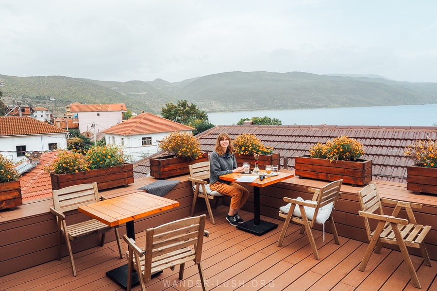 A woman sitting on a rooftop terrace overlooking Lake Ohrid.