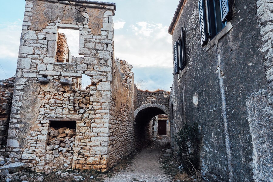 An archway made of stone blocks stretches between houses in the village of Qeparo.