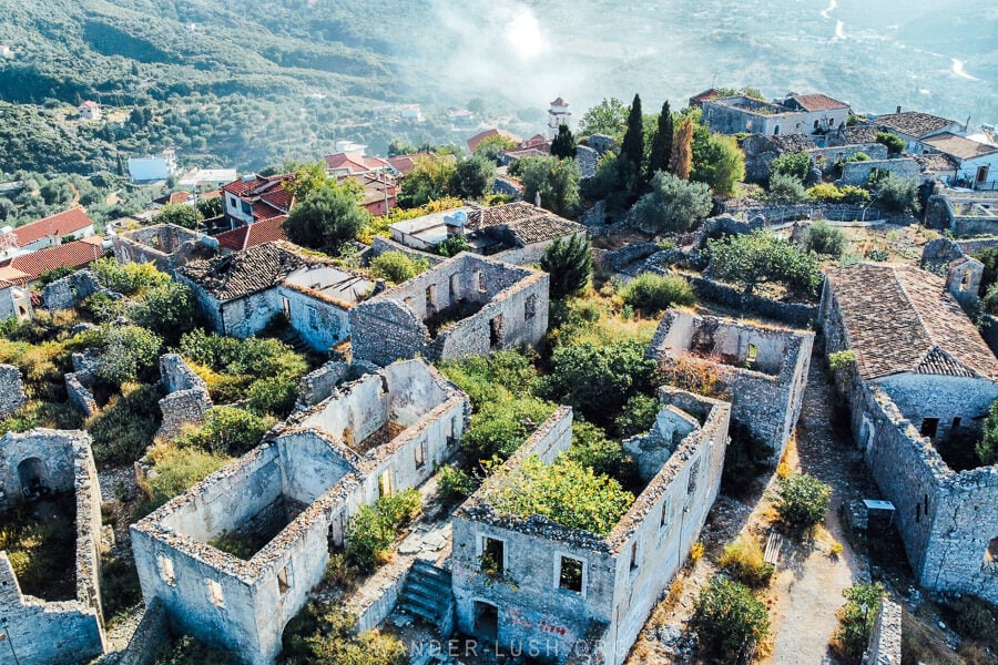 A drone photo of Himara Castle, ancient stone buildings on a cliff edge in Himara Albania.