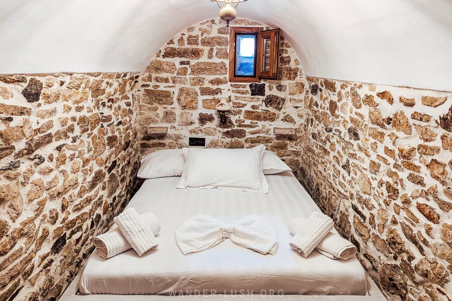 A bed set inside a cosy arched nook at Villa Porta Qeparo boutique hotel.