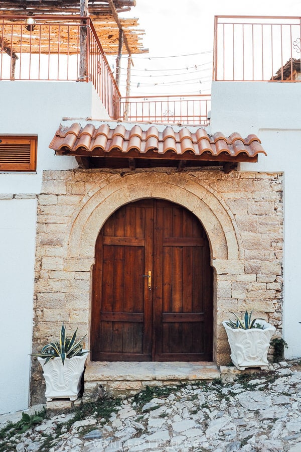 An arched wooden door in a stone facade.