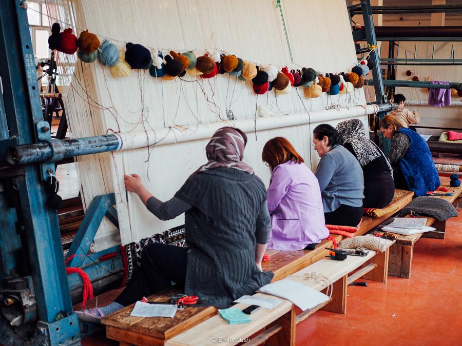 Women weave a large carpet in Quba, Azerbaijan.