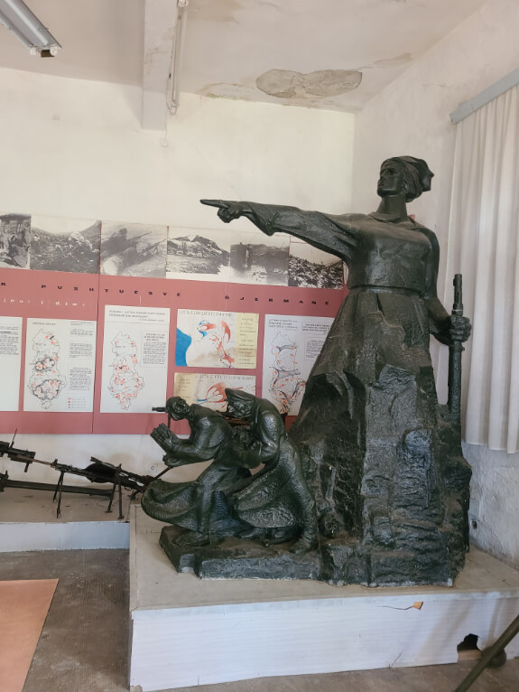 A statue of Albania pointing the Nazis and the church out of the country