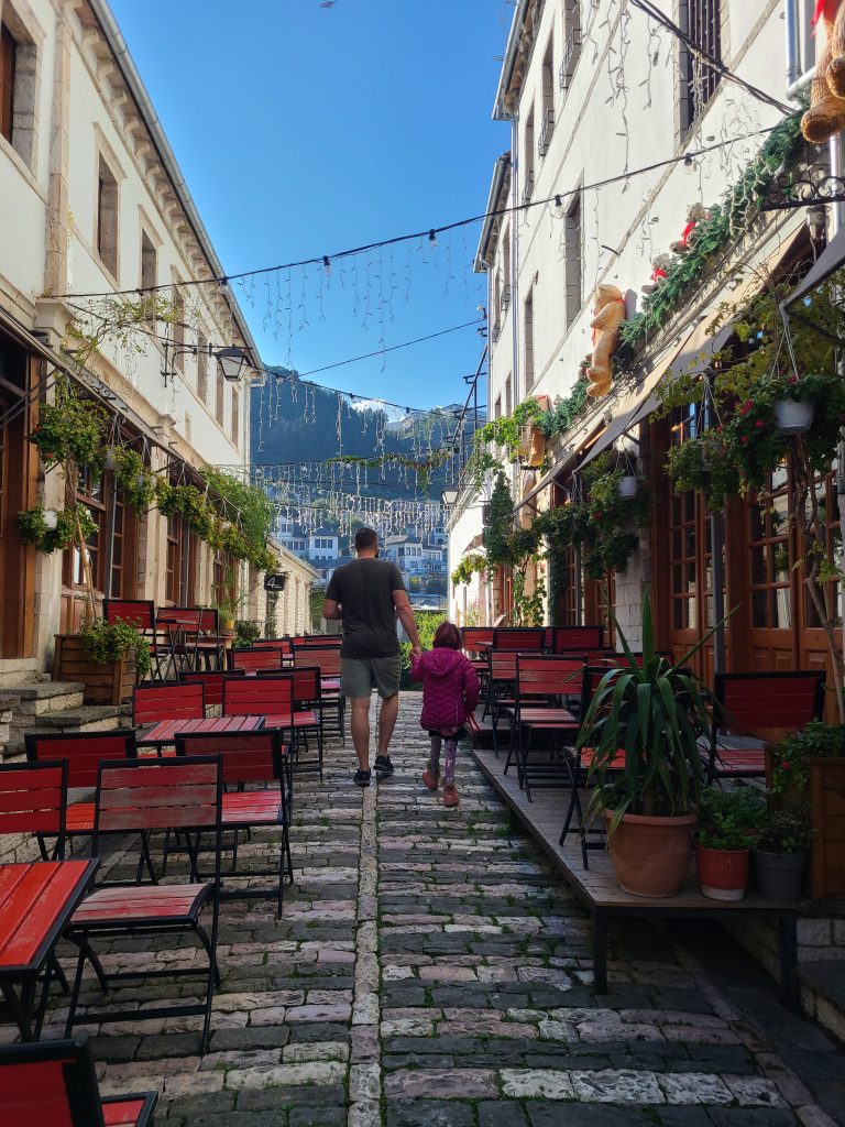 A small street in Gjirokaster with restaurant terraces on each side