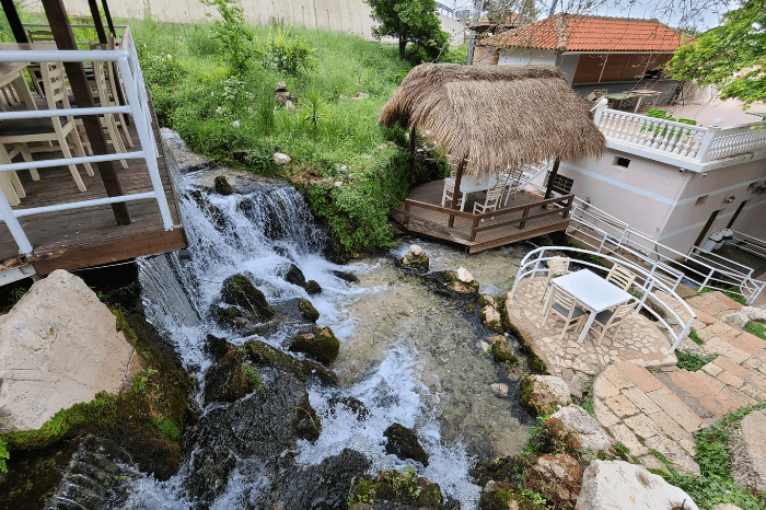 A wide angle shot of Ujvara restaurant patio where a waterfall cascades through a multi terraced dining area.