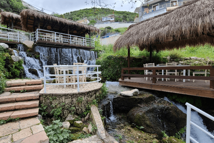 the terraces at Ujvara restaurant with the spring flowing by in the background