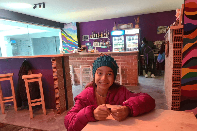 Happy girl in front of a brick bar at Dick and Devil's pub.