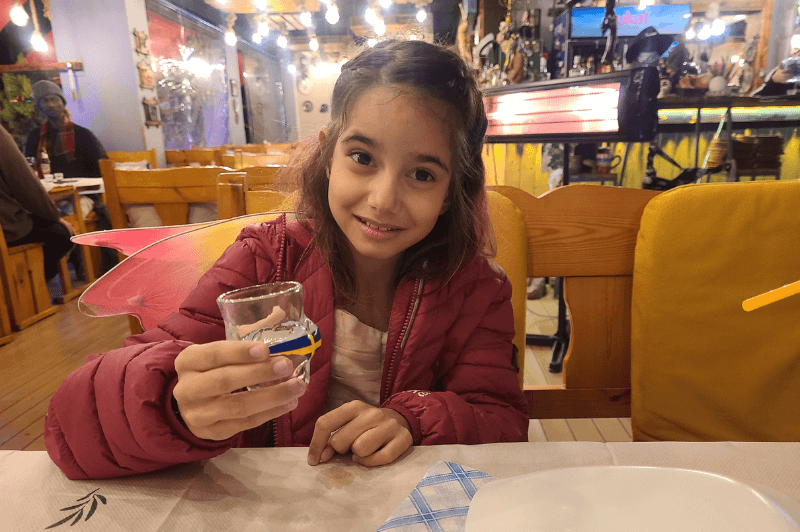 Happy girl holding a bikini  shot glass at Haxhi in Saranda