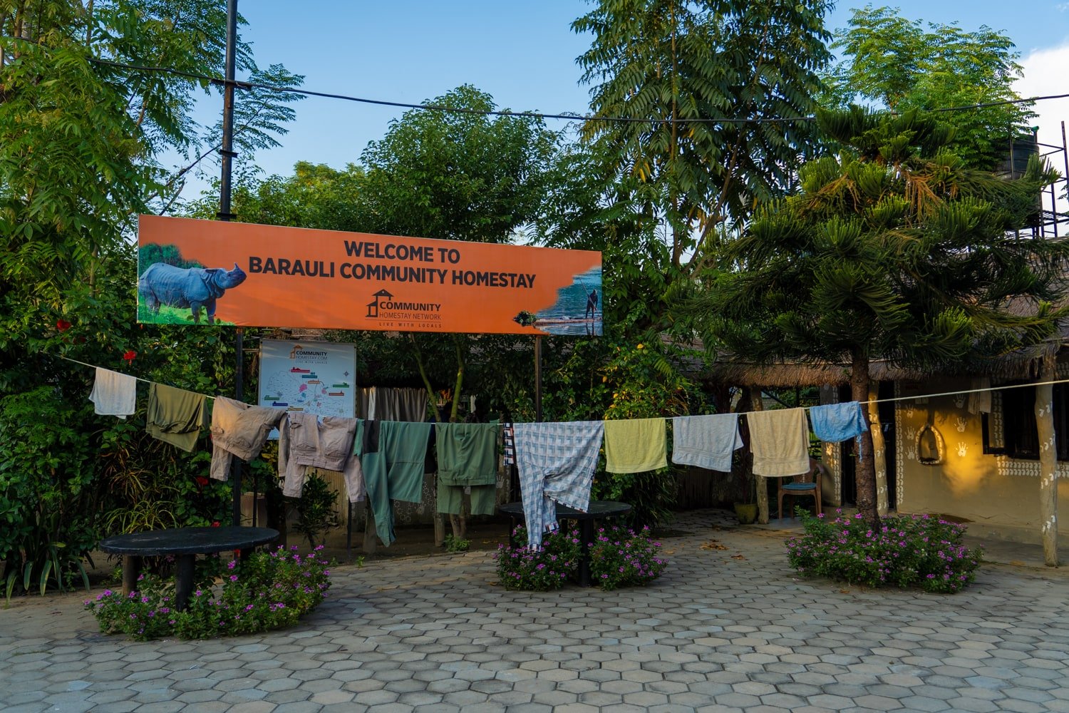 A welcome sign at the Barauli Community Homestay and a clothesline.