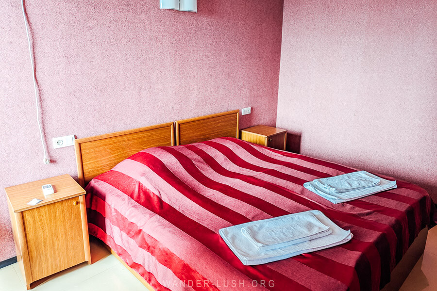 A double bed with a pink bedspread at the Hotel Rustavi.